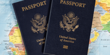 Pair of passports laying on a map of the world.