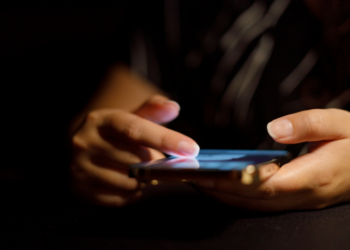 Doom-scrolling on a cell phone in the dark.