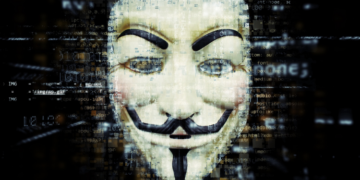 Guy Fawkes mask with traces of programming code swirling around it.